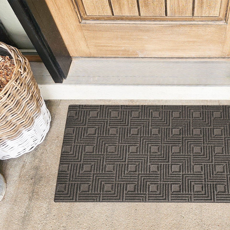 An all-weather Labyrinth doormat in green at the outside entrance of a home.