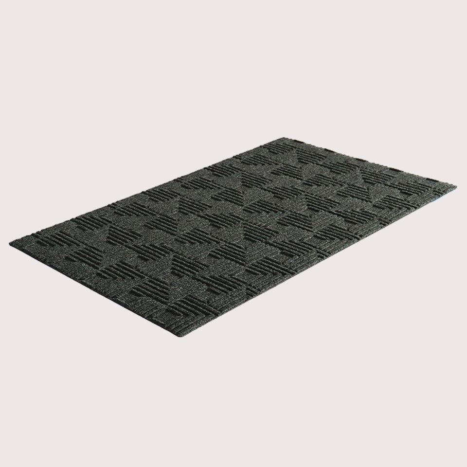 Angled image of the single-door Labyrinth mat in the color graphite on a creamy white background.