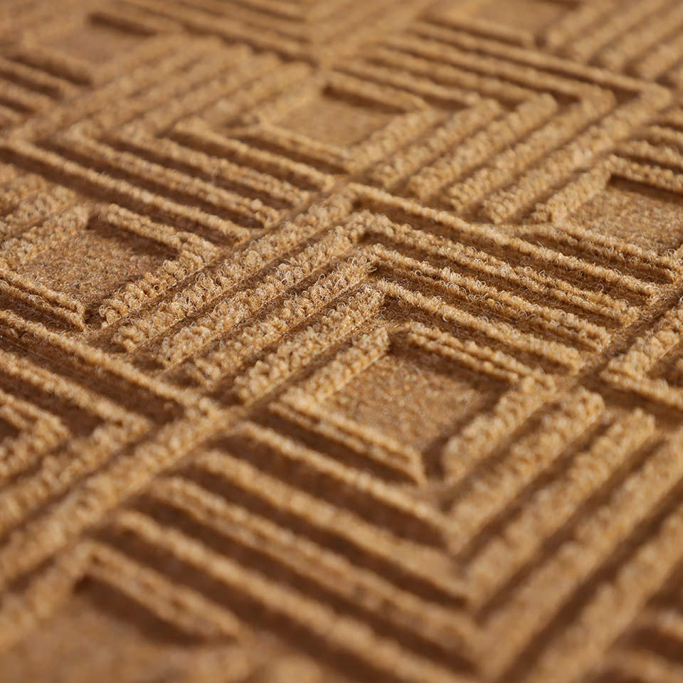 Up close, detailed image of Labyrinth’s surface, capturing the complex linear design carved out by the bi-level surface, shown in wheat.