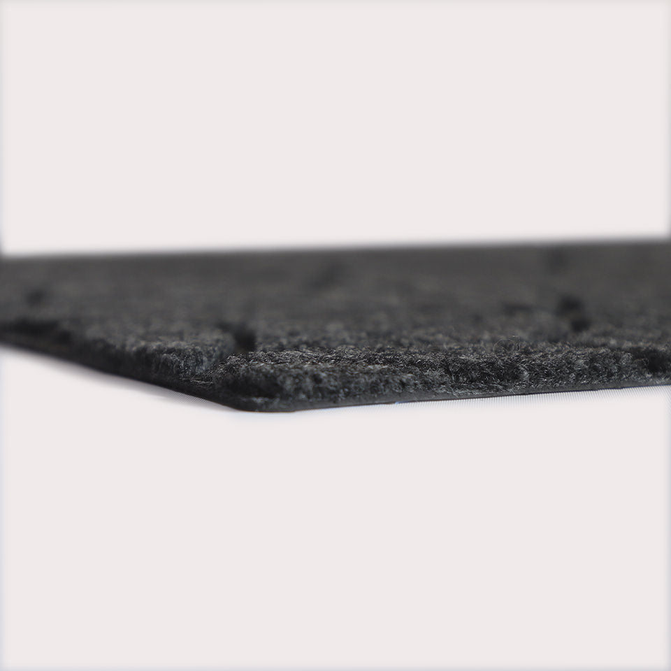Profile corner image of the Magnolia doormat in graphite, showing the overall 3/8” height and rubber backing. 