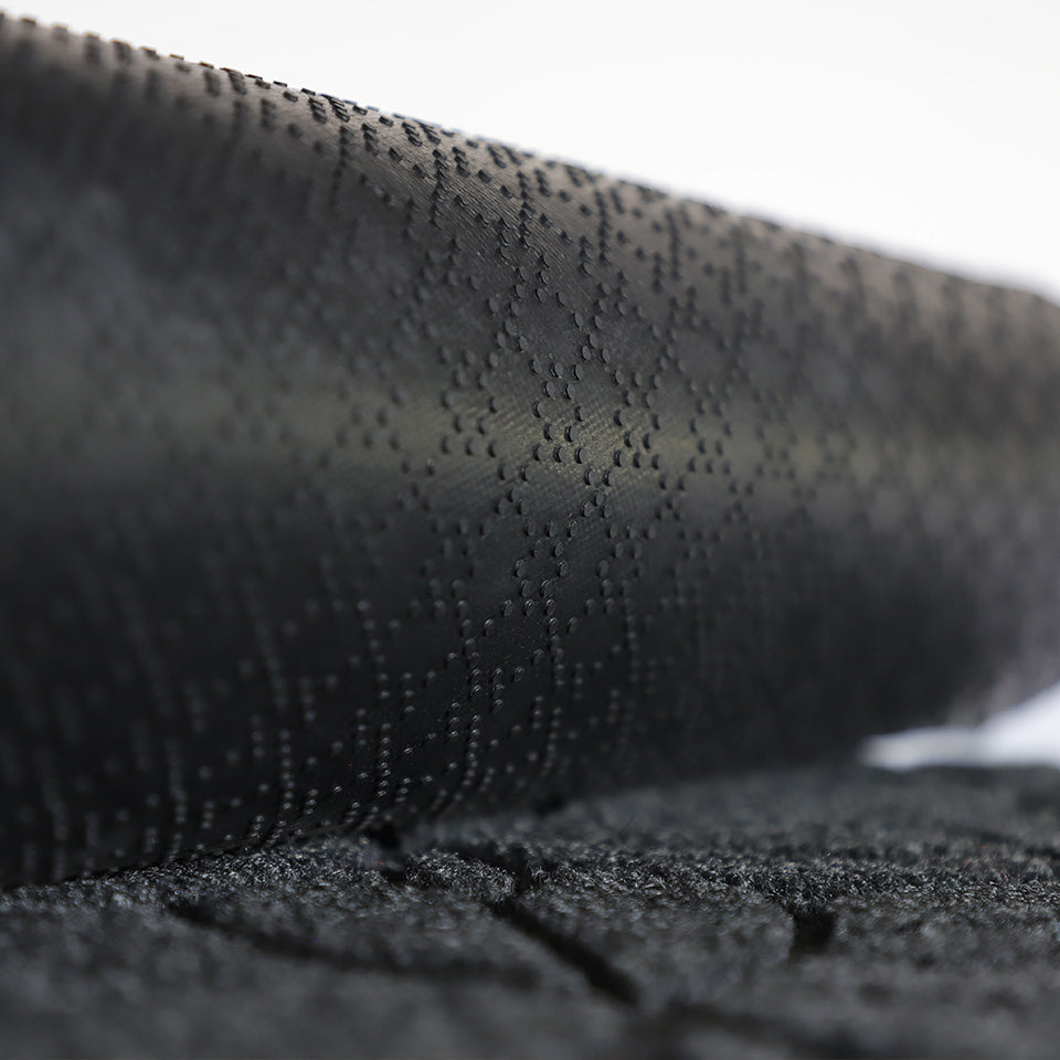 A close-up image of the all-weather Magnolia mat half rolled showing both the rubber backing and graphite surface.