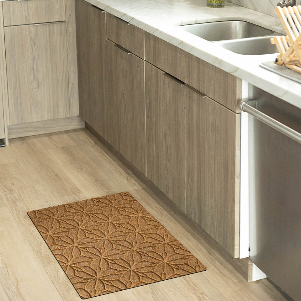 The beautiful WaterHog Luxe Magnolia mat in a kitchen, in front of the sink. Its wheat color pulls from the warmth of the wood floors and decorations.