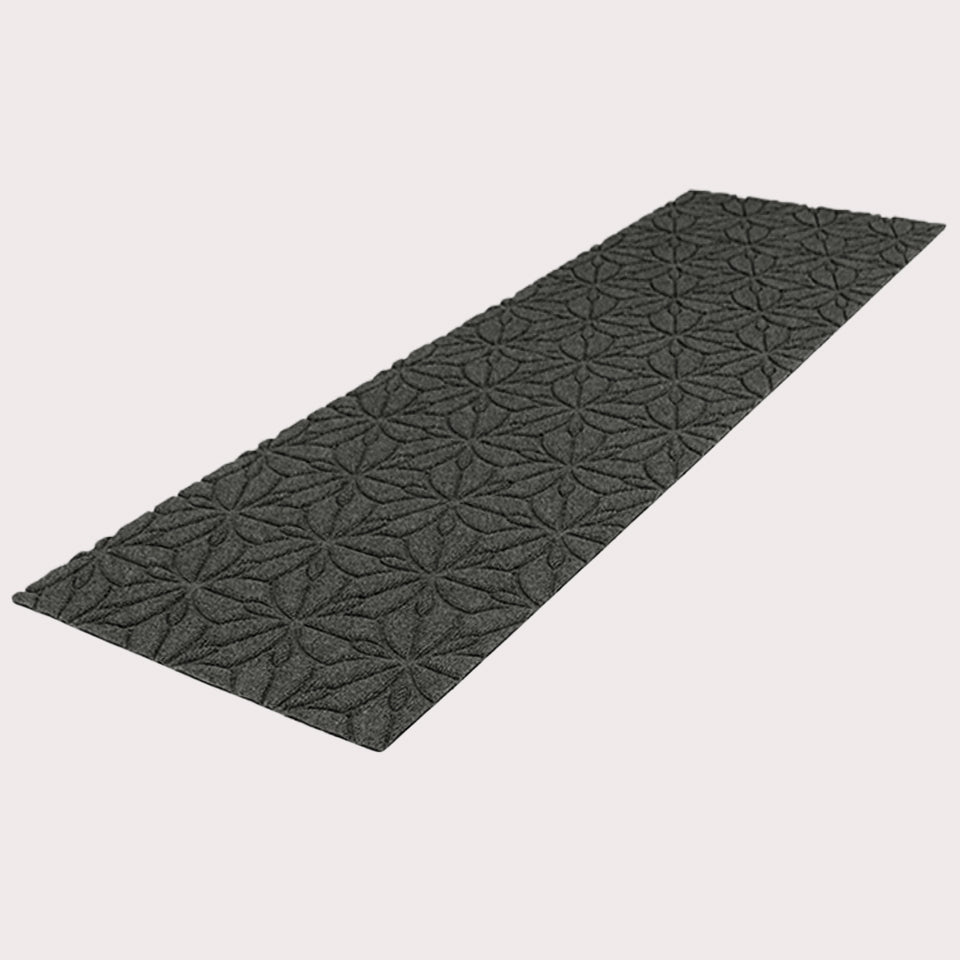 Angled image of the double-door Magnolia mat in the color graphite on a creamy white background. 