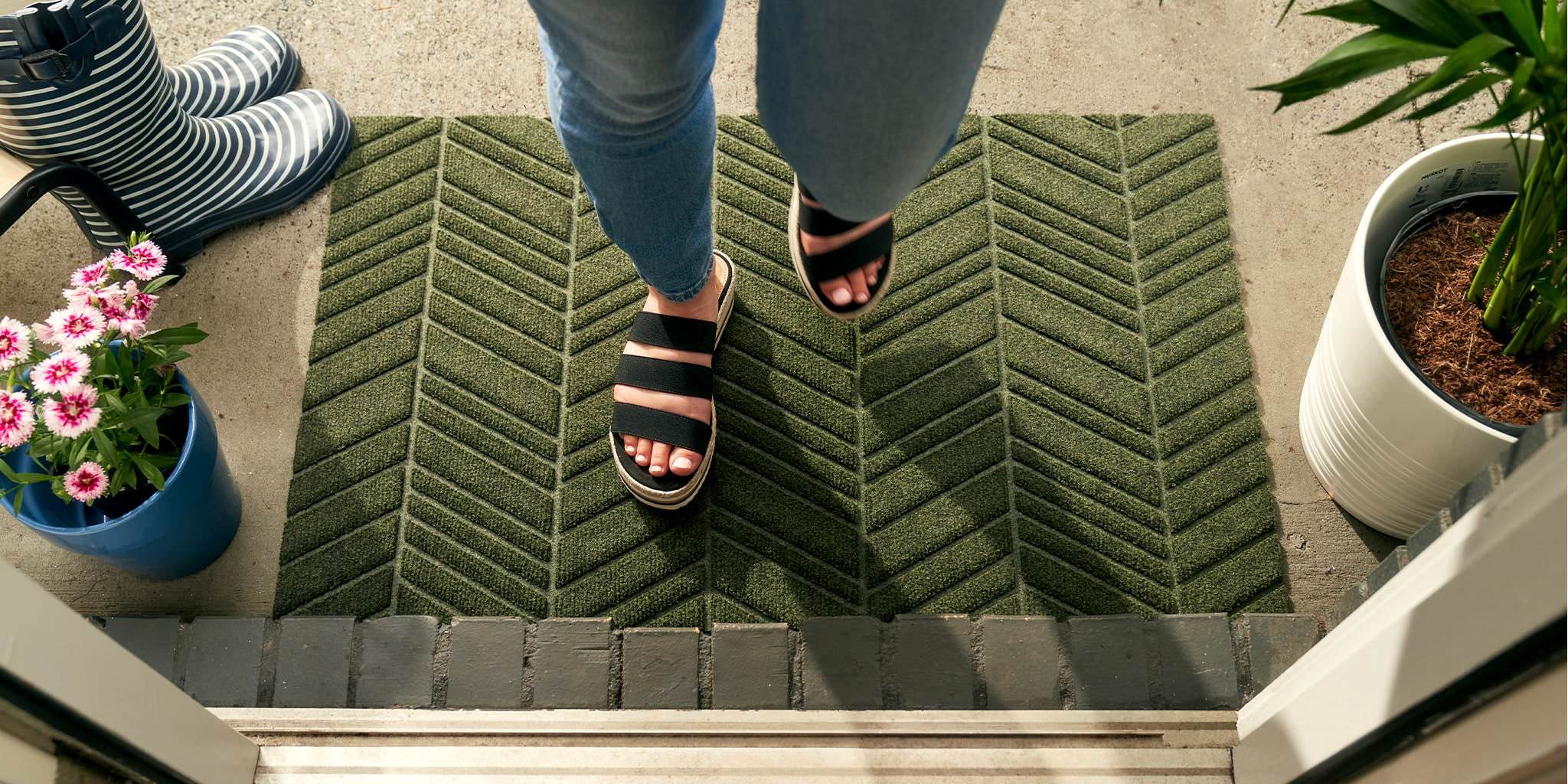 WaterHog Luxe indoor outdoor green doormat placed at the front door to help catch the grass, dirt, and moisture.