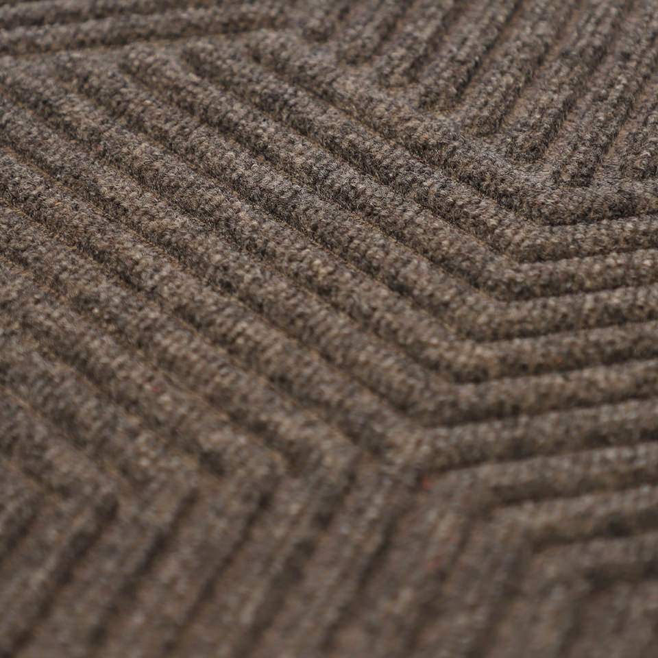 Close up of greige geometric doormat in zephyr