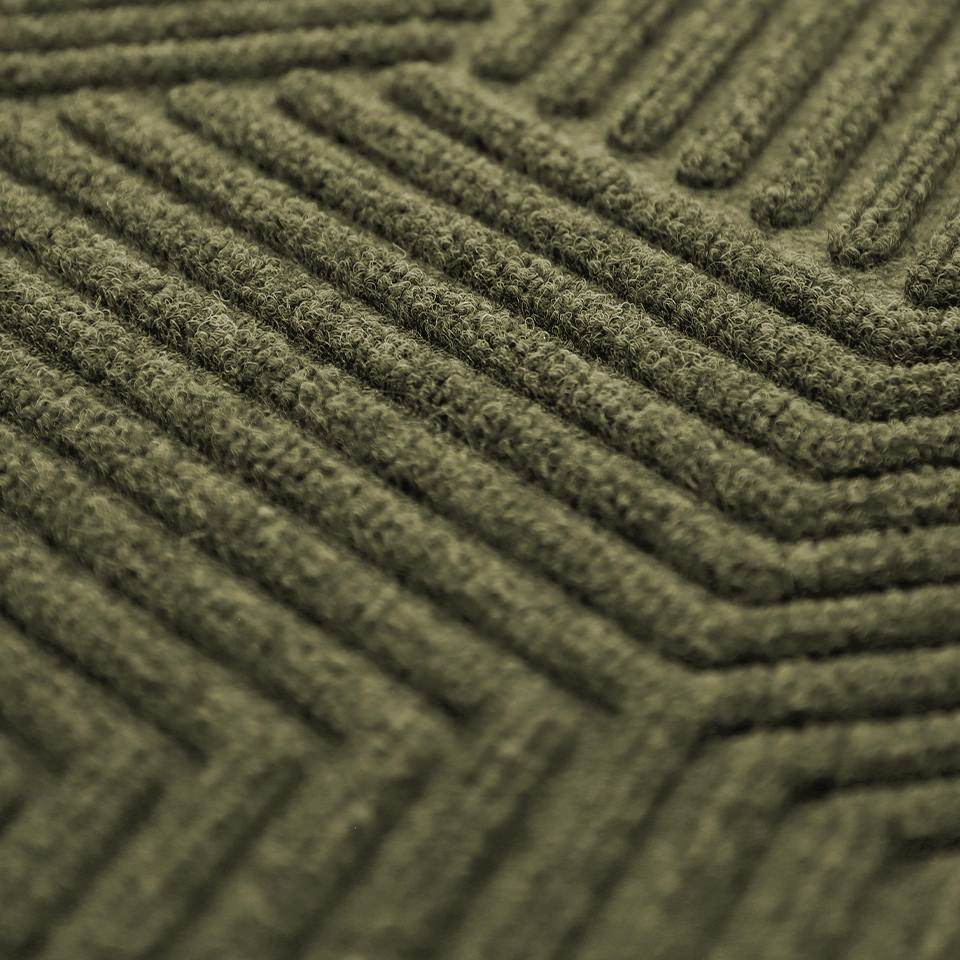 Close up of olive green zephyr geometric pattern doormat with focus on the bi-level dirt trapping layers