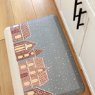 Kitchen comfort mat with a kitschy gingerbread house design; on a wipeable surface