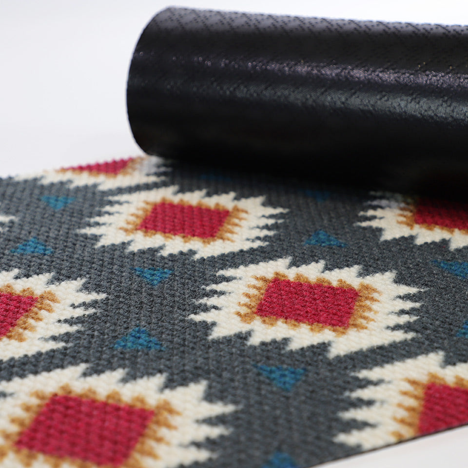 Aztec mat with corner rolled over top to show rubber cleated backing