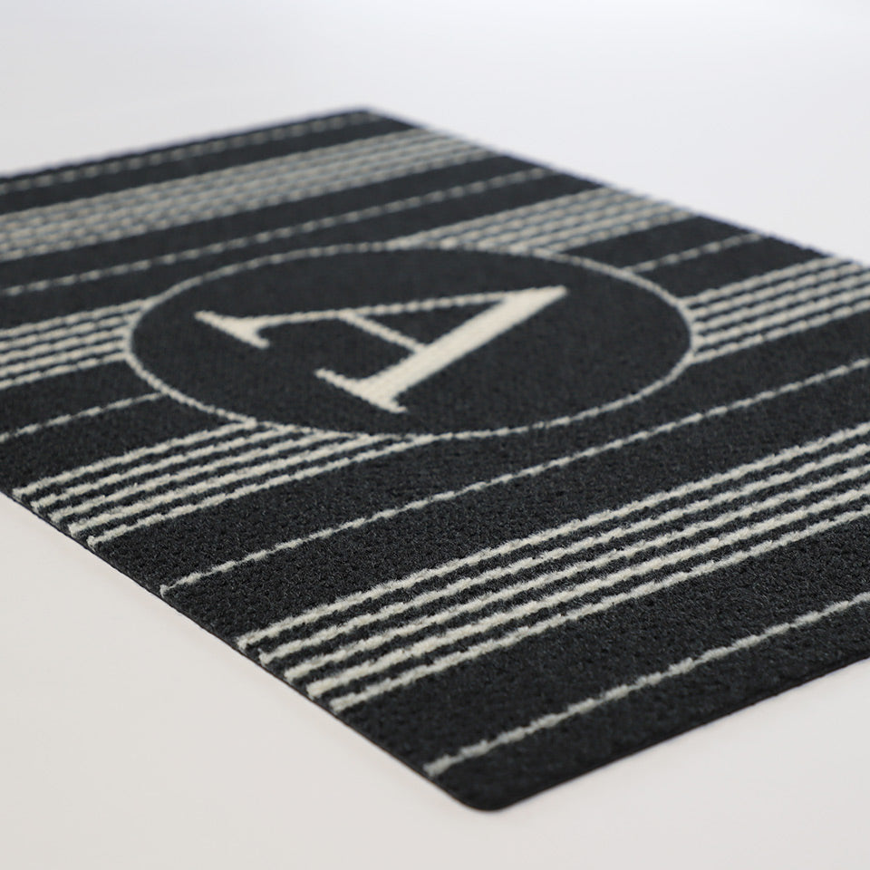 close up image of black and white basic stripe mat with monogrammed A