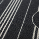 close up of basic stripe monogram doormat. thin white stripes on a black background