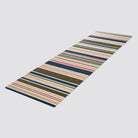 Angled shot of double door striped doormat in brown pink and navy stripes