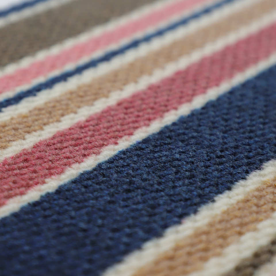 Close up of non shedding striped doormat with pink brown and navy stripes