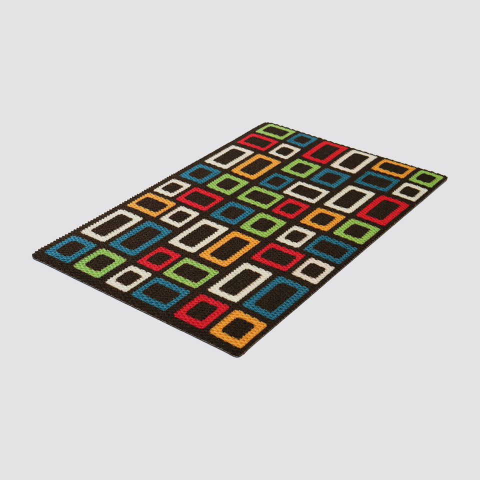 Isolated image of colorful MCM inspired square design doormat on dark brown background
