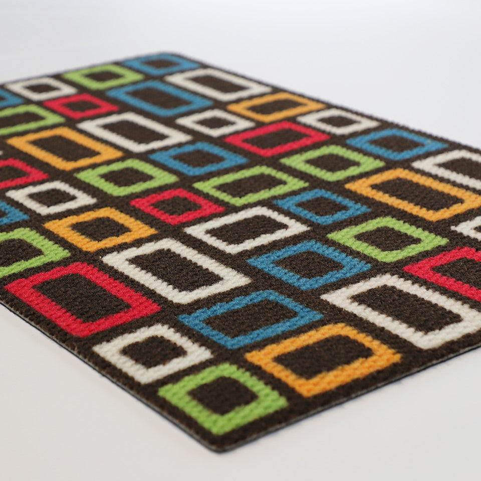 Angle shot of doormat with retro MCM inspired colorful squares on a dark brown background