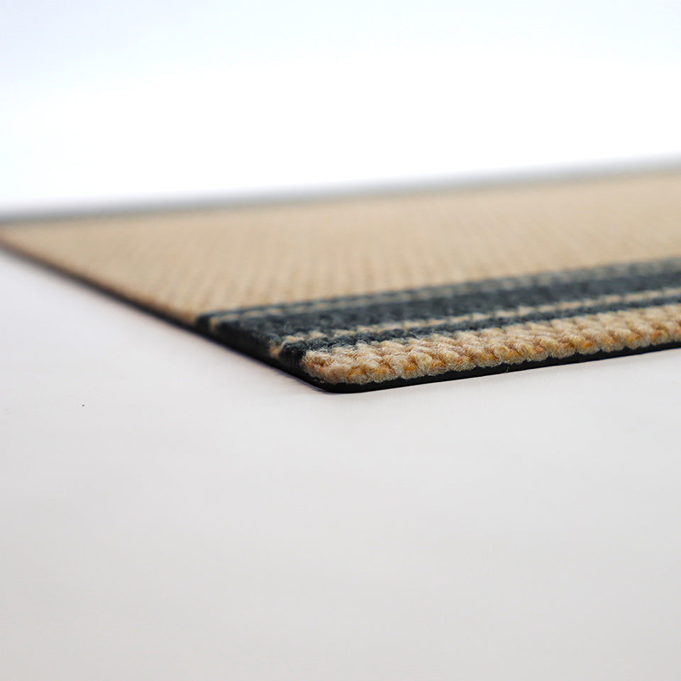 Angle low profile shot of black and tan striped doormat