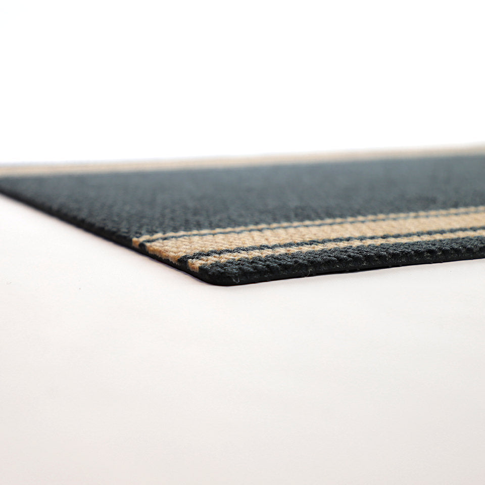 Close up low profile shot of black and tan striped doormat