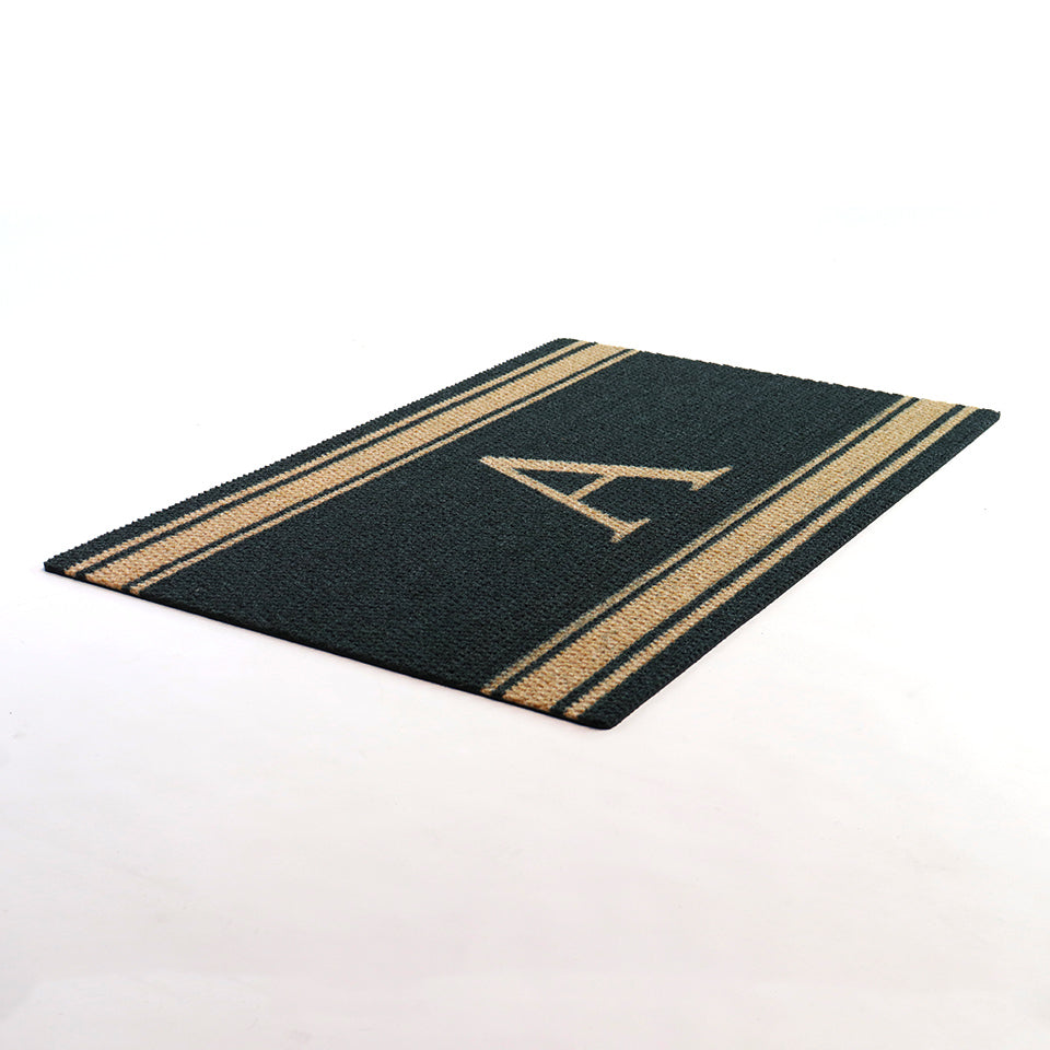 Angle shot of Coir monogram on black mat with coir stripes at top and bottom