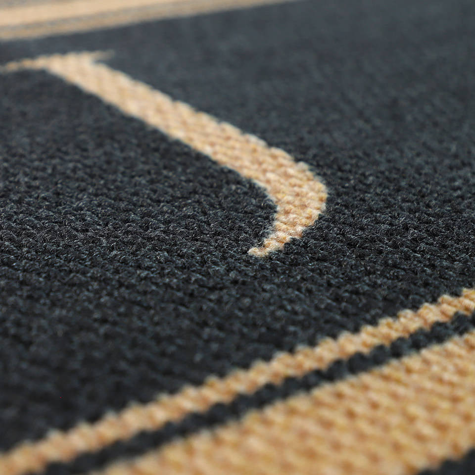 Close up of monogram on coir and black striped monogrammed doormat