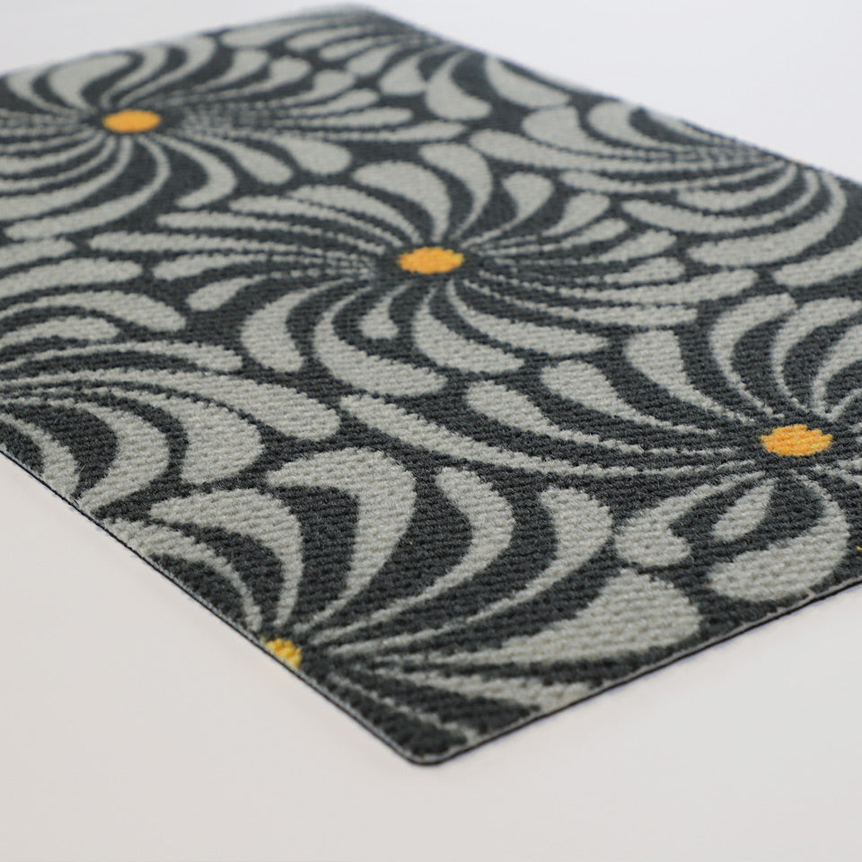 Close up angle of retro funky grey and yellow floral non shedding doormat