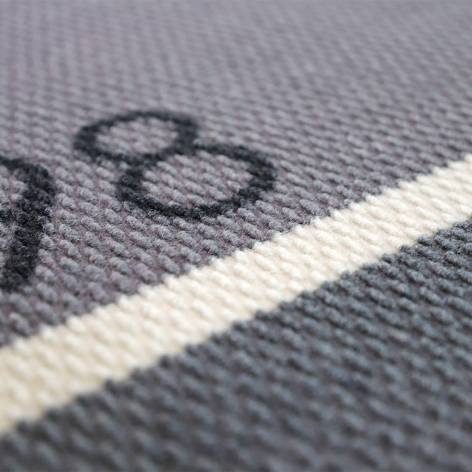 Close up of non shedding doormat in personalized Modern Main grey