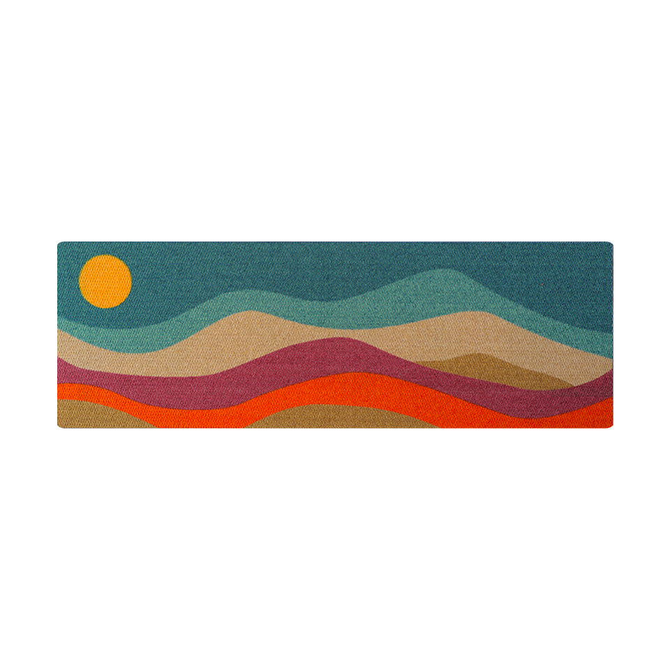 The Neighburly Mountain Sunset Decorative Doormat features a bright and colorful landscape of blues, browns, oranges, reds, and yellow.