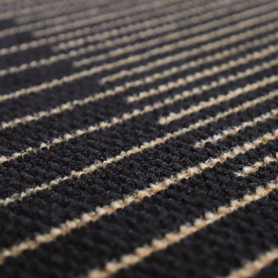 Here's a close up image of the black and tan recycled fibers featured in the geometric style On the Horizon decorative doormat; which is also a non shedding doormat.