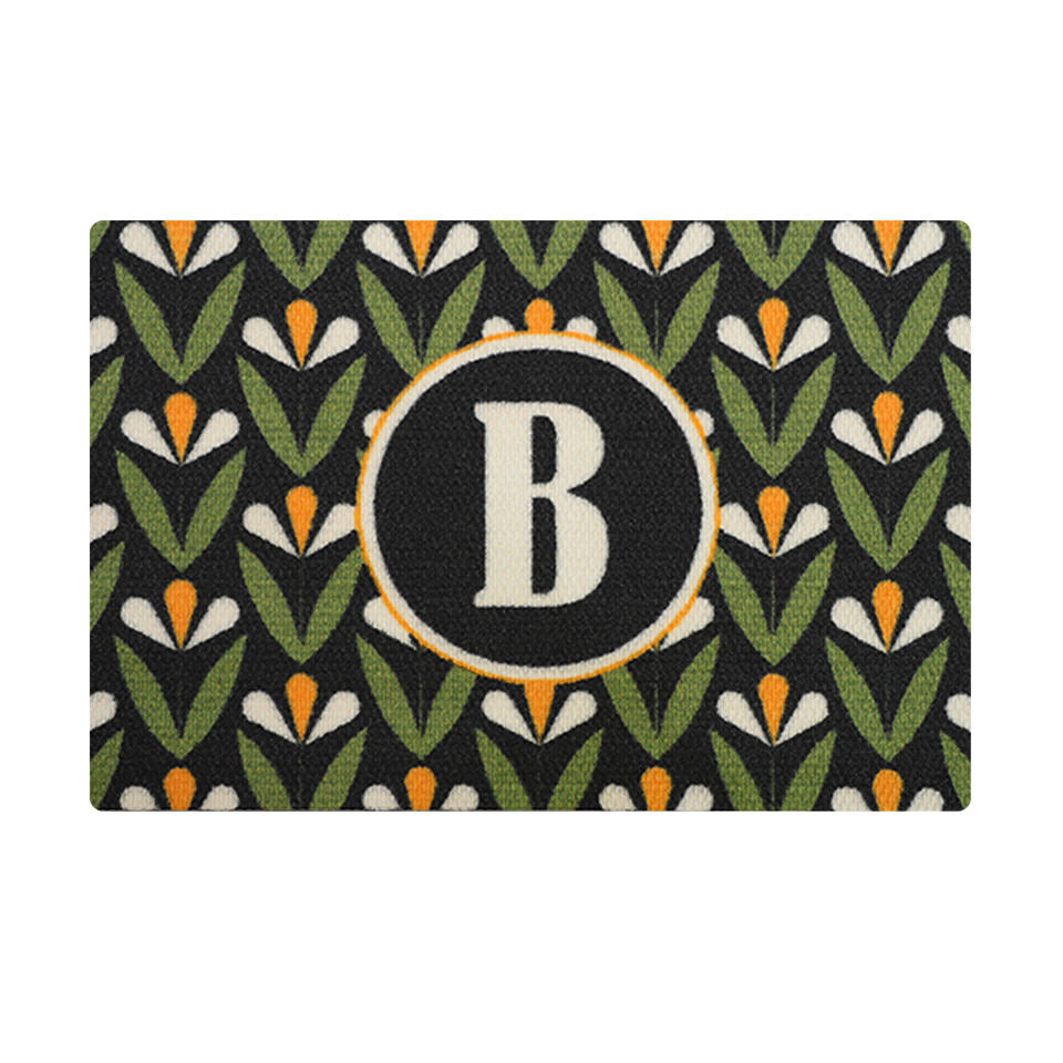 Spring Blooms monogrammed doormat offers a customized look to your front door or entryway. Shown in Yellow and white blooms, green leaves on a black background