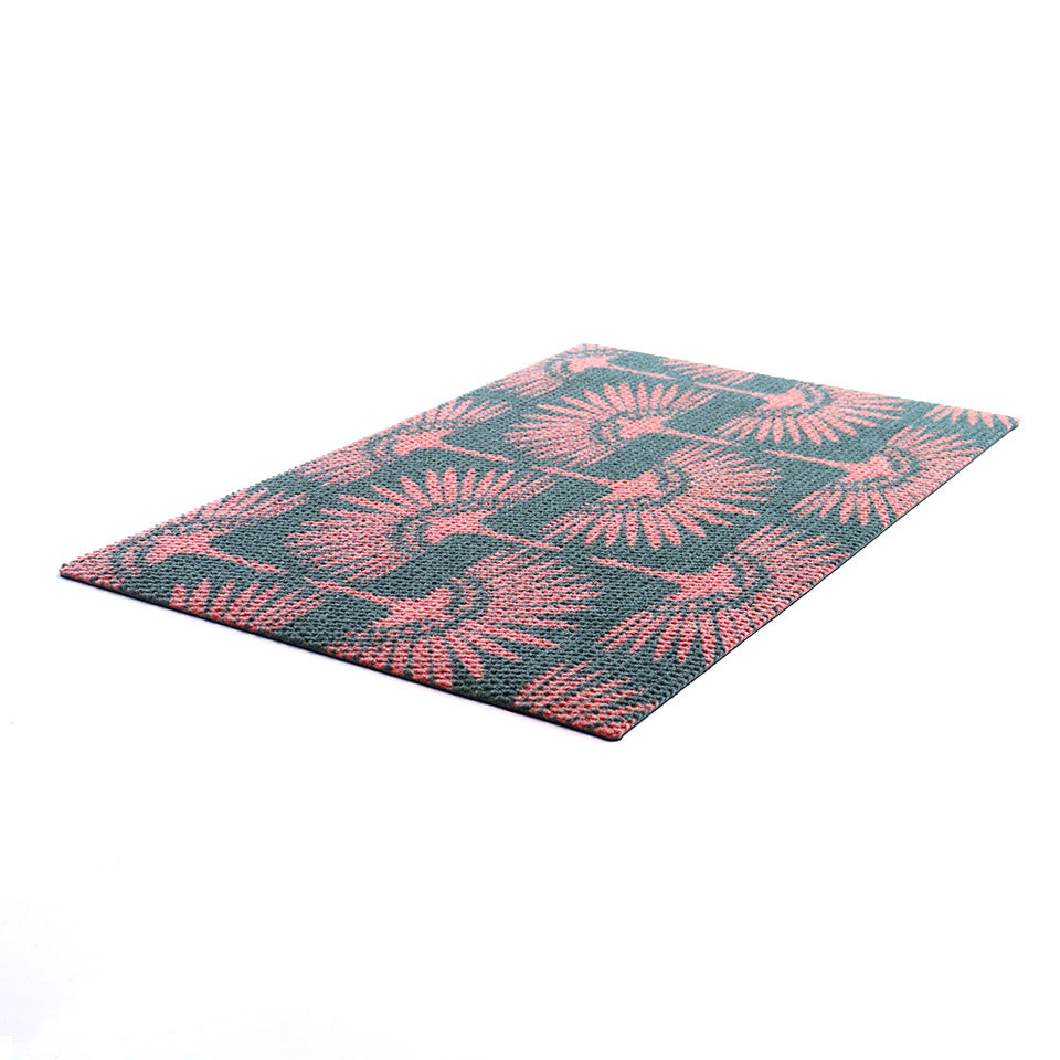 Angled shot of Tailfeathers modern crane retro inspired doormat in pink and grey.