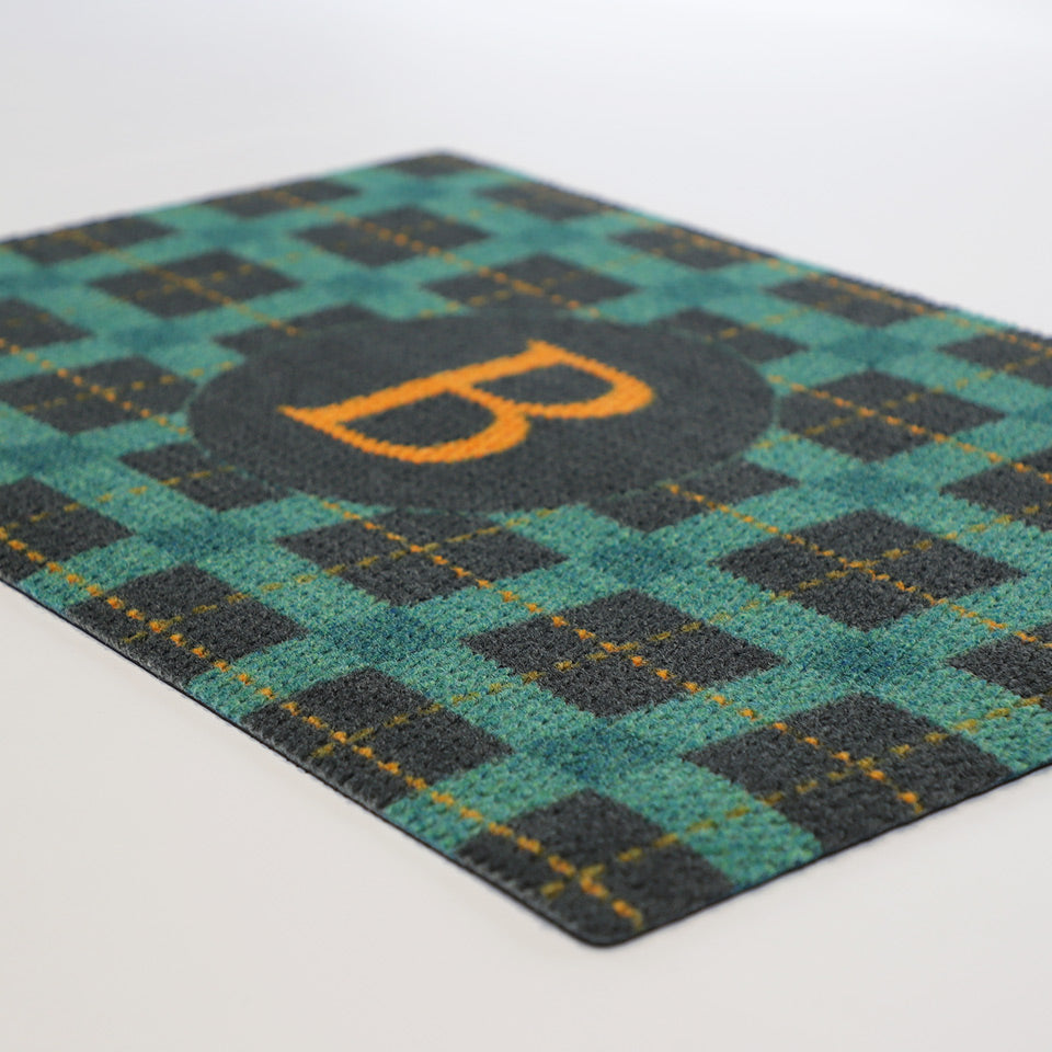 Angled doormat photo of plaid monogrammed personalized doormat in teal, gold, and dark grey