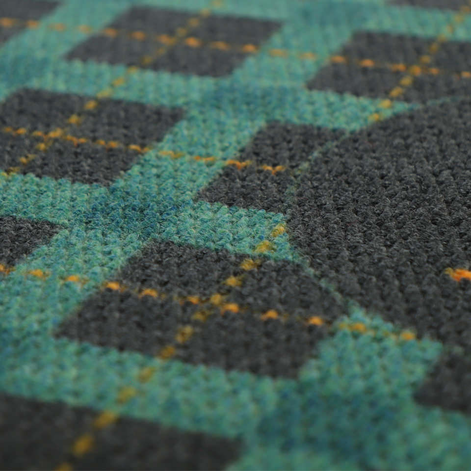 Close up of eco friendly stain resistant doormat in teal, yellow, and grey plaid.