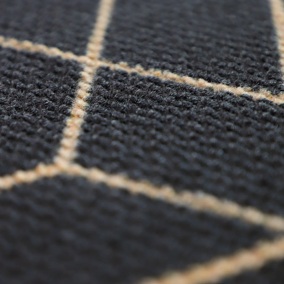 Close up of our non shedding texture on our Triangulation doormat - a geometric pattern in black and tan.