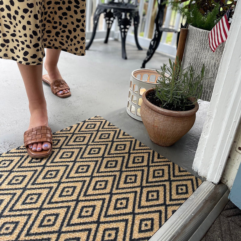 single size diamond dot doormat in coir and black placed in entryway