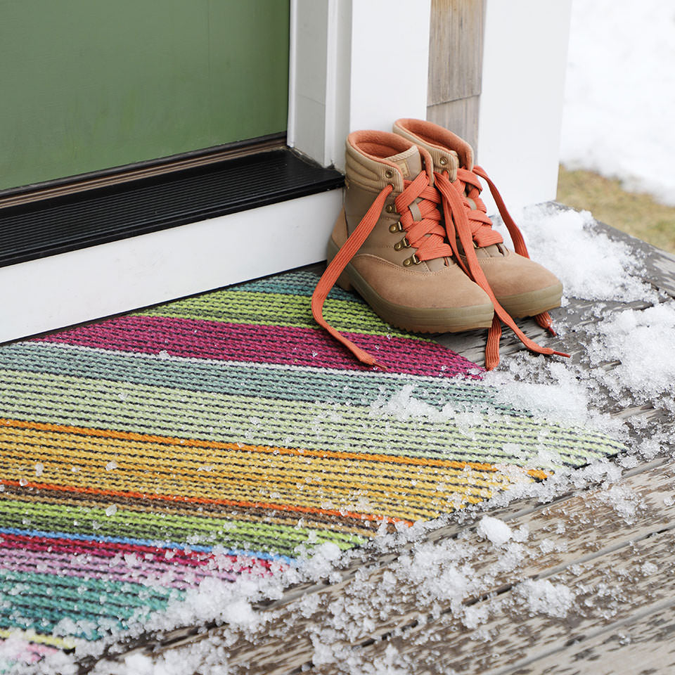 close up of dutch fields horizontal doormat outside door with snow on and around it